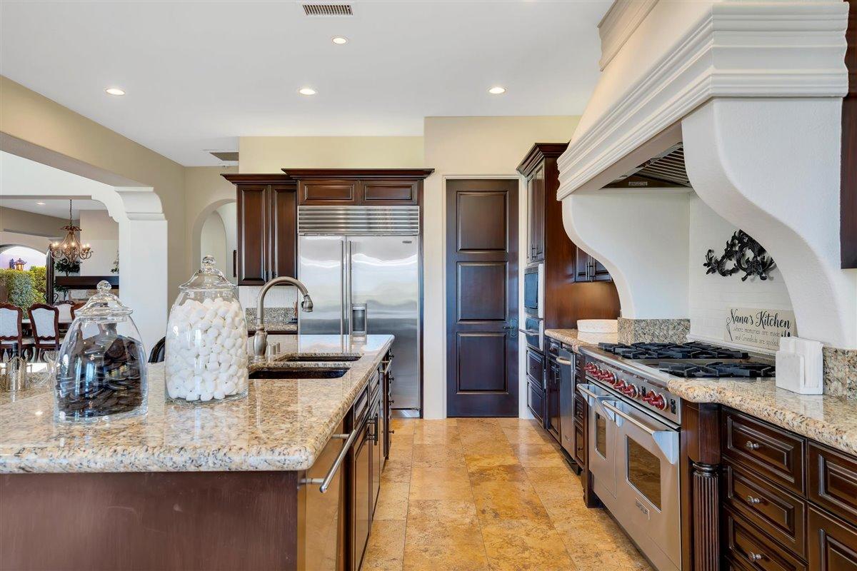 58445 Carmona La Quinta, CA 92253 - Photo 16 of 70 a kitchen with stainless steel appliances granite countertop a stove and a sink