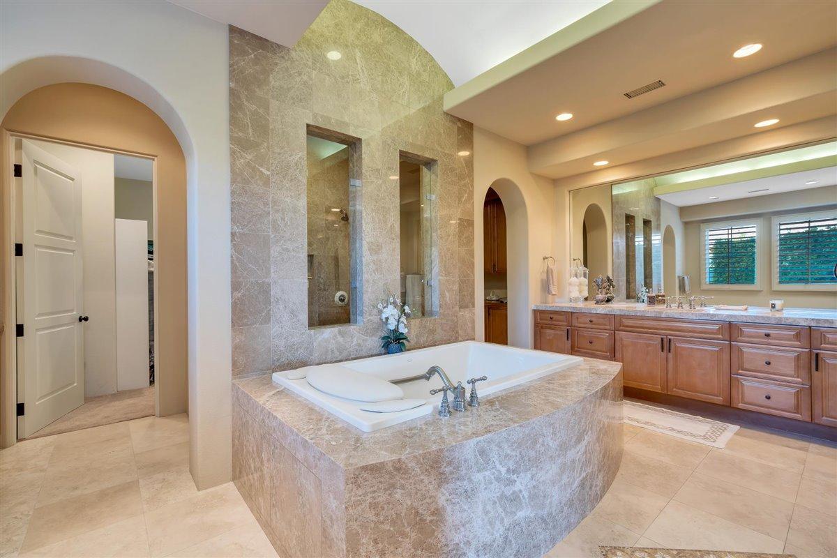 58445 Carmona La Quinta, CA 92253 - Photo 21 of 70 a large bathroom with a tub a double vanity sink and a large mirror