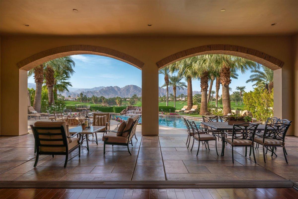 58445 Carmona La Quinta, CA 92253 - Photo 35 of 70 a dining room with furniture large windows and wooden floor
