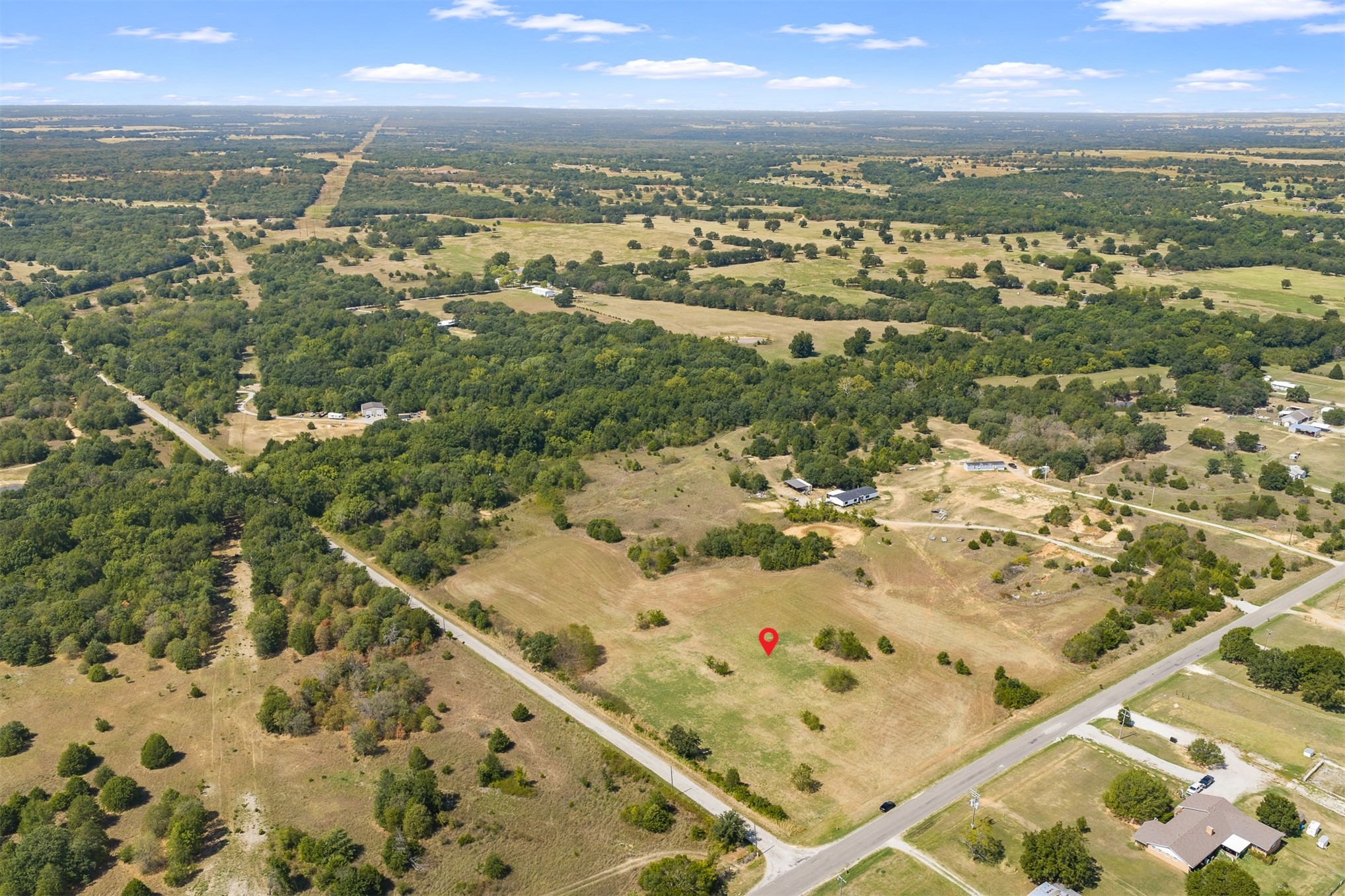 162 Big Bear Road Lone Grove, OK 73443 - Photo 2 of 12 Expansive land parcel featuring open fields, scattered mature trees, and direct road frontage