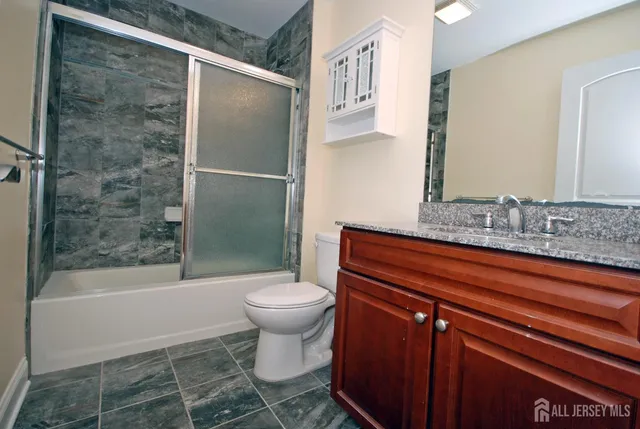a bathroom with a shower toilet and sink