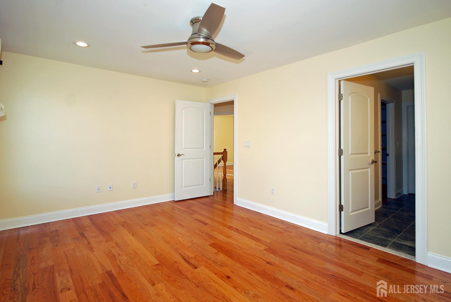 32 Cinder Road, Unit 3 Edison, NJ 08820 - Photo 26 of 34 an empty room with wooden floor and a hallway