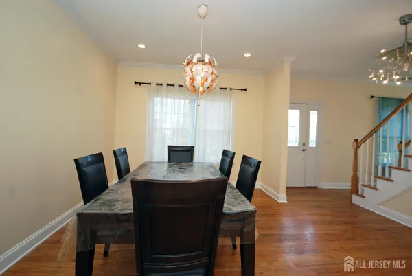 a view of a dining room with furniture a chandelier and wooden floor