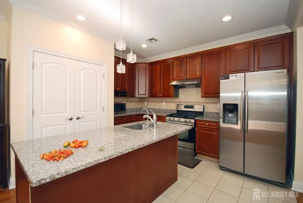 a kitchen with stainless steel appliances granite countertop a sink refrigerator and cabinets