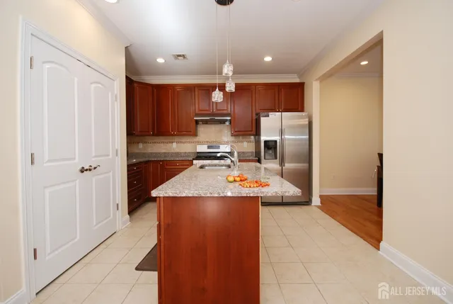 a kitchen with stainless steel appliances granite countertop a refrigerator and a sink