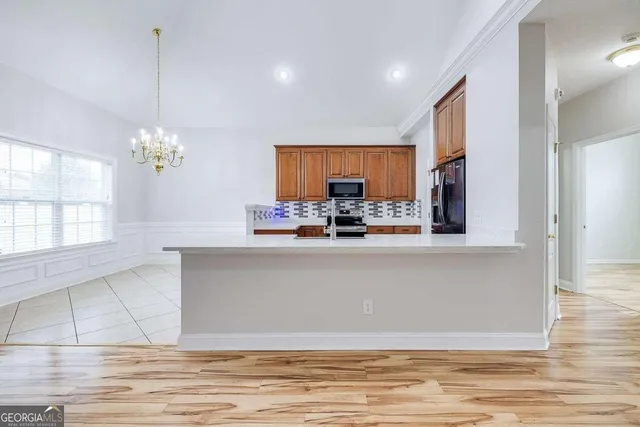 a kitchen with stainless steel appliances granite countertop a stove a sink a refrigerator and a wooden cabinets