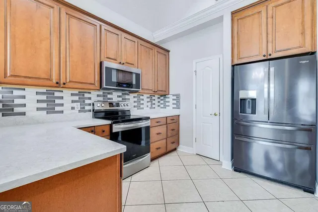 a kitchen with stainless steel appliances granite countertop a refrigerator sink stove and microwave