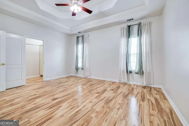 a view of empty room with wooden floor