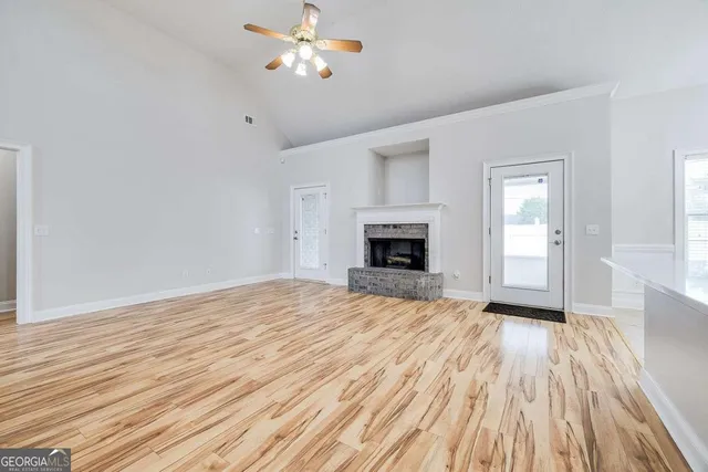 a view of empty room with wooden floor and fireplace