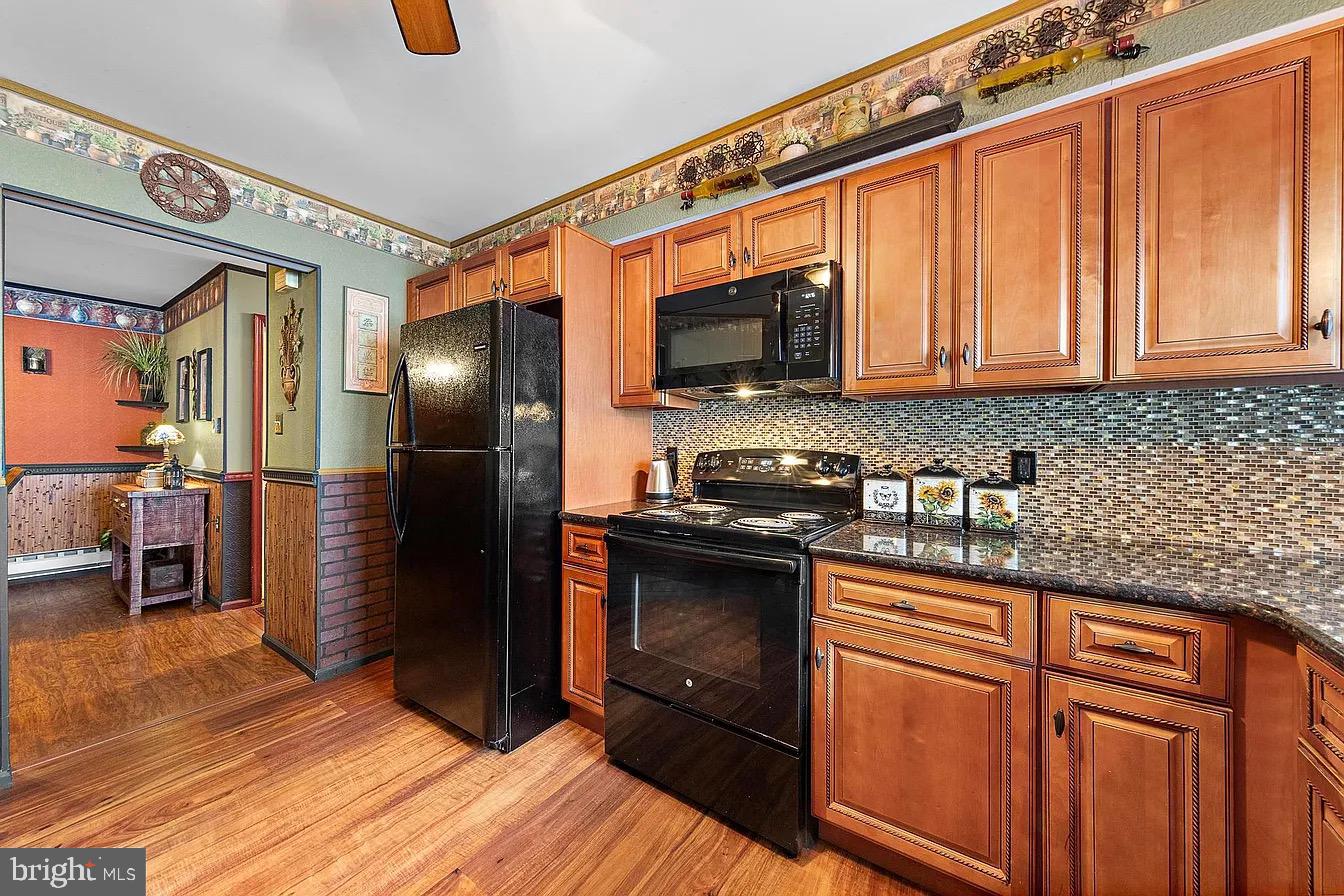 22 Fir Road Manahawkin, NJ 08050 - Photo 19 of 35 a kitchen with stainless steel appliances granite countertop a refrigerator a stove and a sink with wooden floors