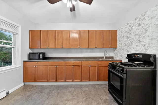 a kitchen with stainless steel appliances granite countertop a stove a sink and a microwave