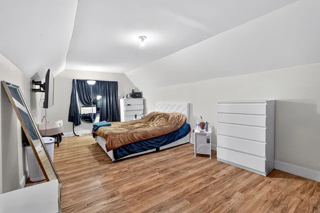 a spacious bedroom with a bed and a dresser