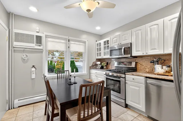 a kitchen with stainless steel appliances granite countertop a stove a sink dishwasher a refrigerator with a dining table and chairs