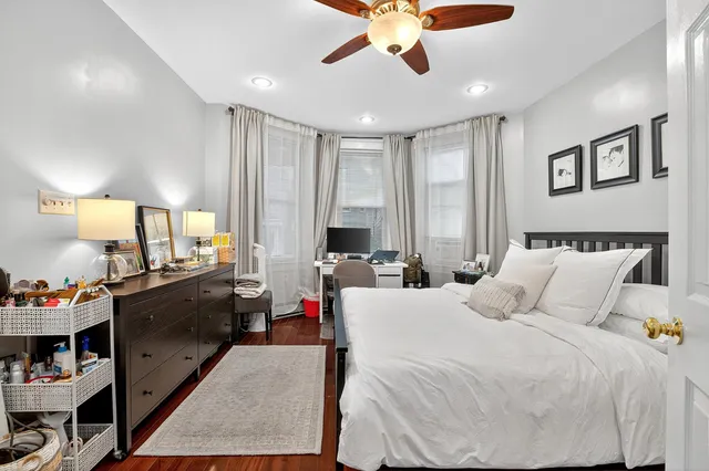 a large bedroom with bed and a large window