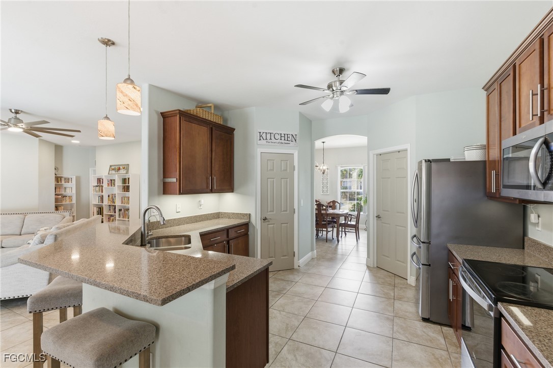 2412 Nature Pointe Loop Fort Myers, FL 33905 - Photo 15 of 44 a kitchen with kitchen island granite countertop a sink appliances and cabinets