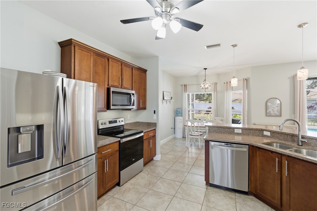 2412 Nature Pointe Loop Fort Myers, FL 33905 - Photo 18 of 44 a kitchen with granite countertop stainless steel appliances a sink and counter space