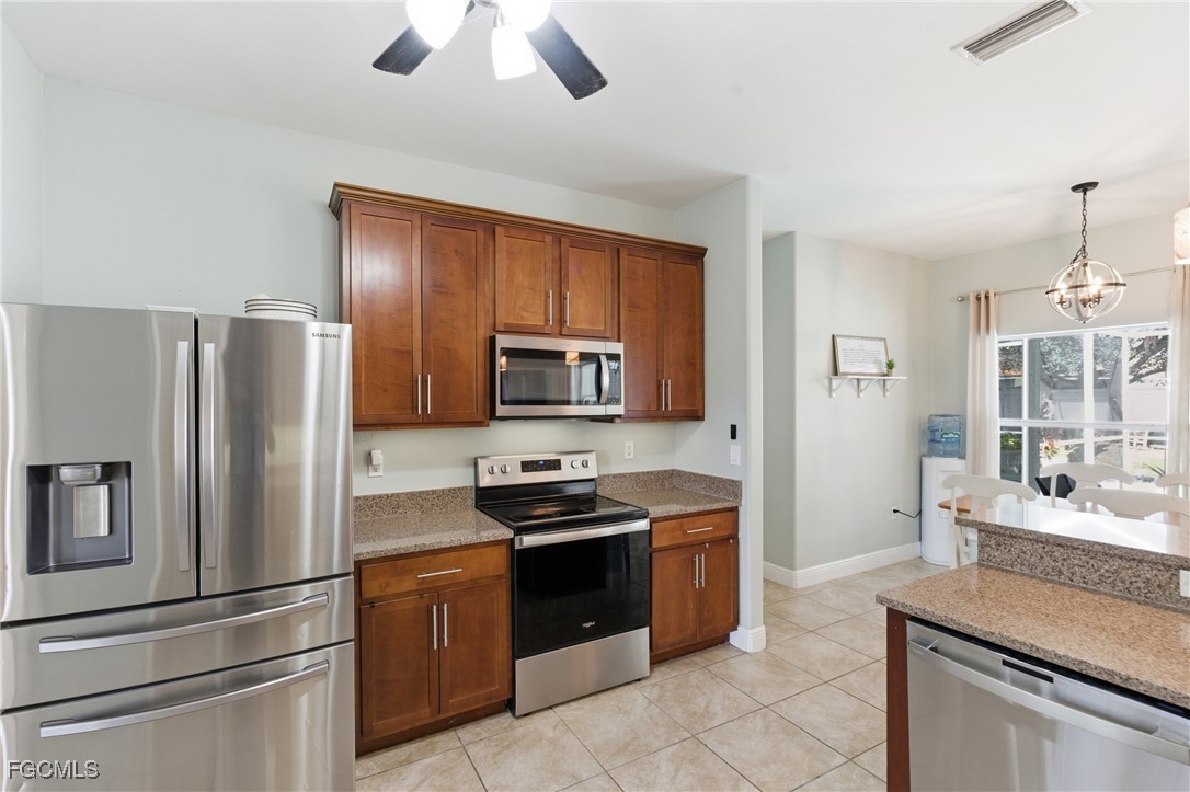 2412 Nature Pointe Loop Fort Myers, FL 33905 - Photo 19 of 44 a kitchen with stainless steel appliances granite countertop a refrigerator stove top oven and sink