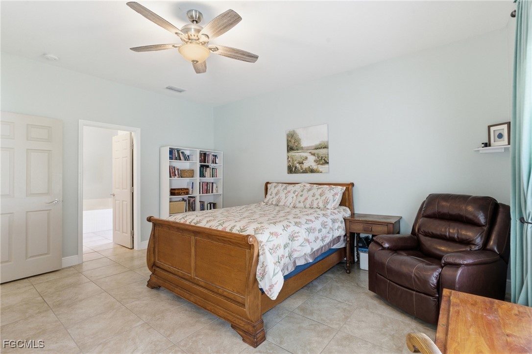 2412 Nature Pointe Loop Fort Myers, FL 33905 - Photo 25 of 44 a bedroom with a bed and a chandelier