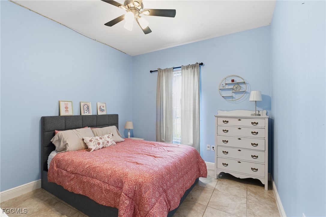 2412 Nature Pointe Loop Fort Myers, FL 33905 - Photo 30 of 44 a bedroom with a bed and a chandelier