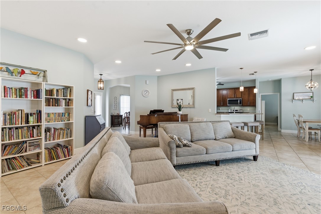 2412 Nature Pointe Loop Fort Myers, FL 33905 - Photo 5 of 44 a living room with furniture and a book shelf