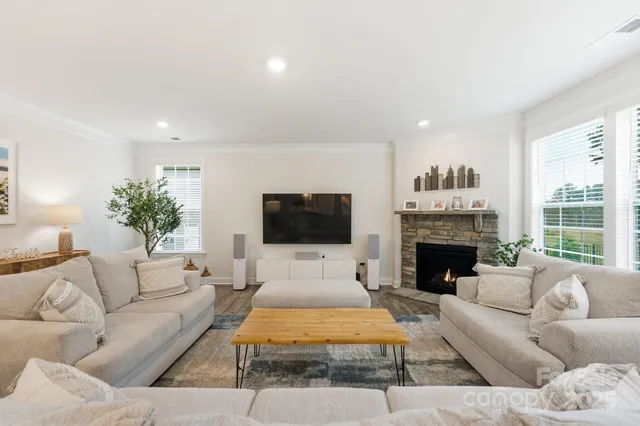 a living room with furniture a flat screen tv and a fireplace