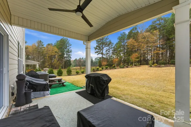 a view of a patio with lawn chairs next to a yard