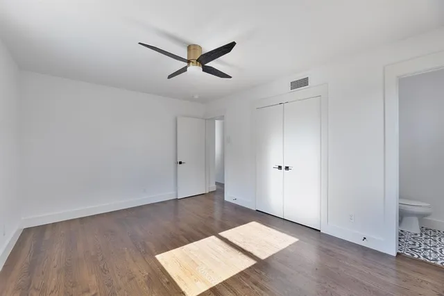 a view of a room with wooden floor and white walls