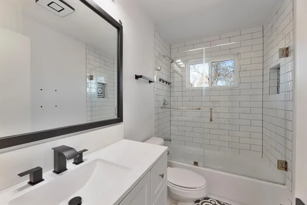 a bathroom with a sink a toilet and shower
