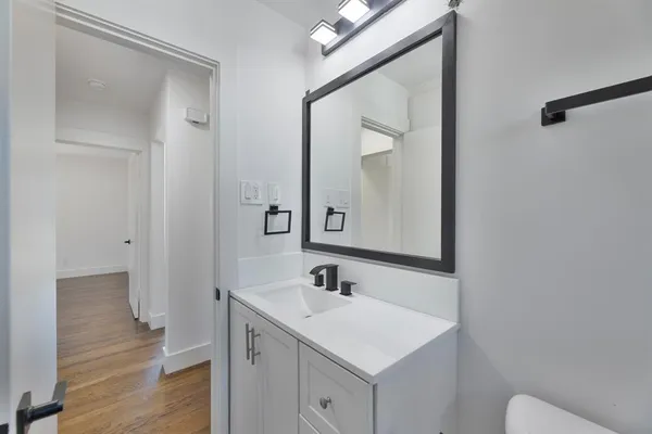 a bathroom with a sink a toilet and a mirror
