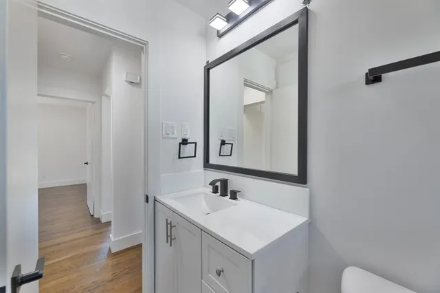 a bathroom with a sink a toilet and a mirror