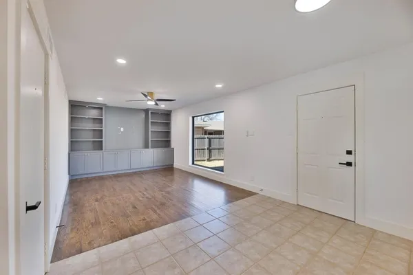 an empty room with wooden floor and cabinet