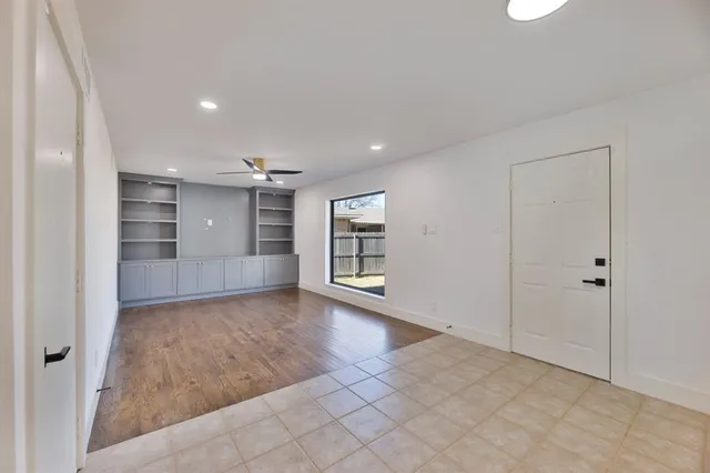 an empty room with wooden floor and cabinet