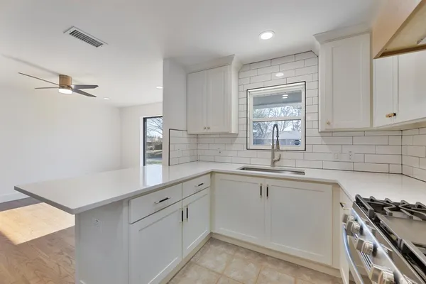a kitchen with cabinets appliances a sink and a window