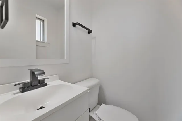 a bathroom with a sink mirror and toilet
