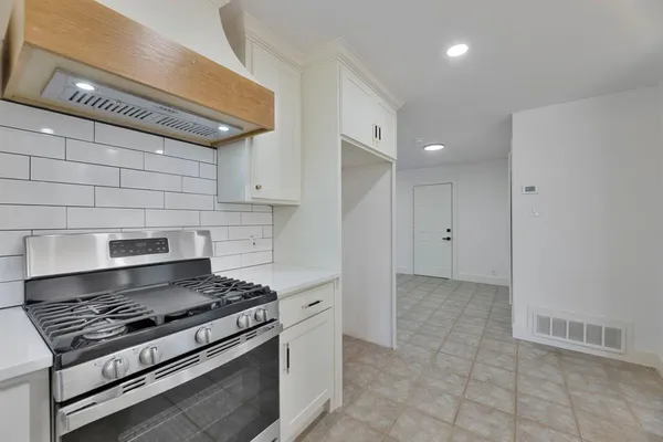 a stove top oven sitting inside of a kitchen
