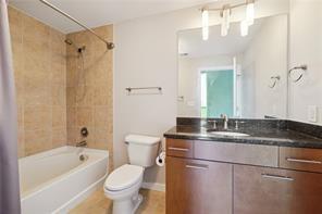 3300 Windy Ridge Parkway Southeast, Unit 913 Atlanta, GA 30339 - Photo 18 of 28 a bathroom with a granite countertop sink toilet mirror and bathtub