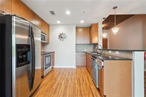 3300 Windy Ridge Parkway Southeast, Unit 913 Atlanta, GA 30339 - Photo 4 of 28 a kitchen with stainless steel appliances granite countertop a refrigerator a sink and a stove
