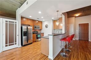 3300 Windy Ridge Parkway Southeast, Unit 913 Atlanta, GA 30339 - Photo 8 of 28 a kitchen with stainless steel appliances kitchen island granite countertop a refrigerator and a stove