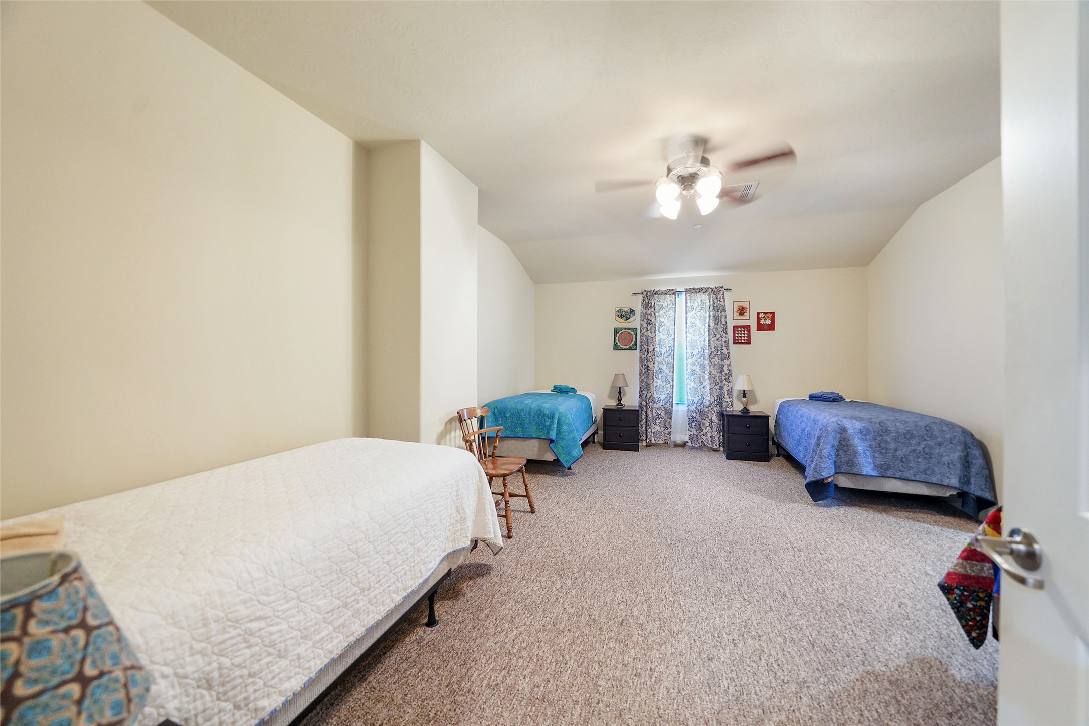 26250 B Riley Road Waller, TX 77484 - Photo 22 of 45 Large upstairs bedroom with multiple beds, neutral walls, carpeted flooring, and natural light, ideal for group or dorm-style accommodations.