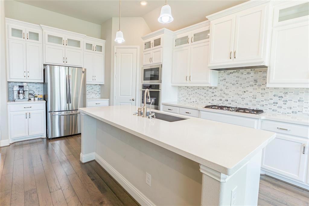 3920 Bentgrass Road Plano, TX 75023 - Photo 13 of 30 a kitchen with refrigerator cabinets and wooden floor