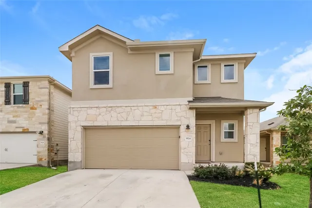 a front view of a house with a yard and garage