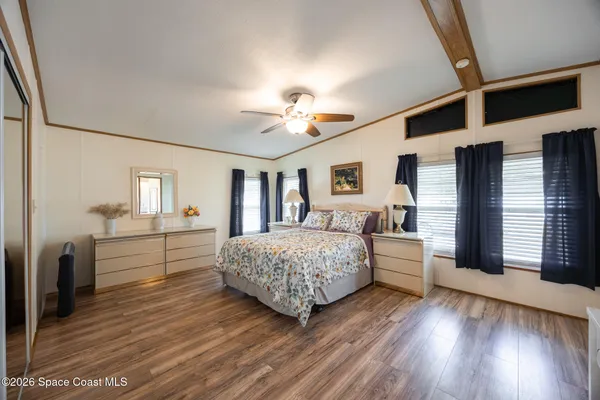 a bedroom with a large bed and a chandelier