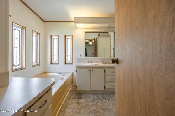 a bathroom with a tub sink and mirror