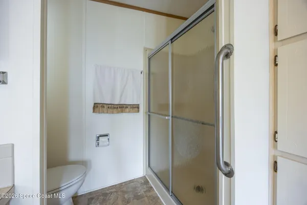 a bedroom with a bed and a refrigerator