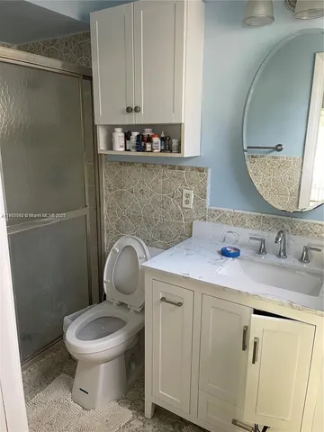 a bathroom with a toilet sink vanity and mirror