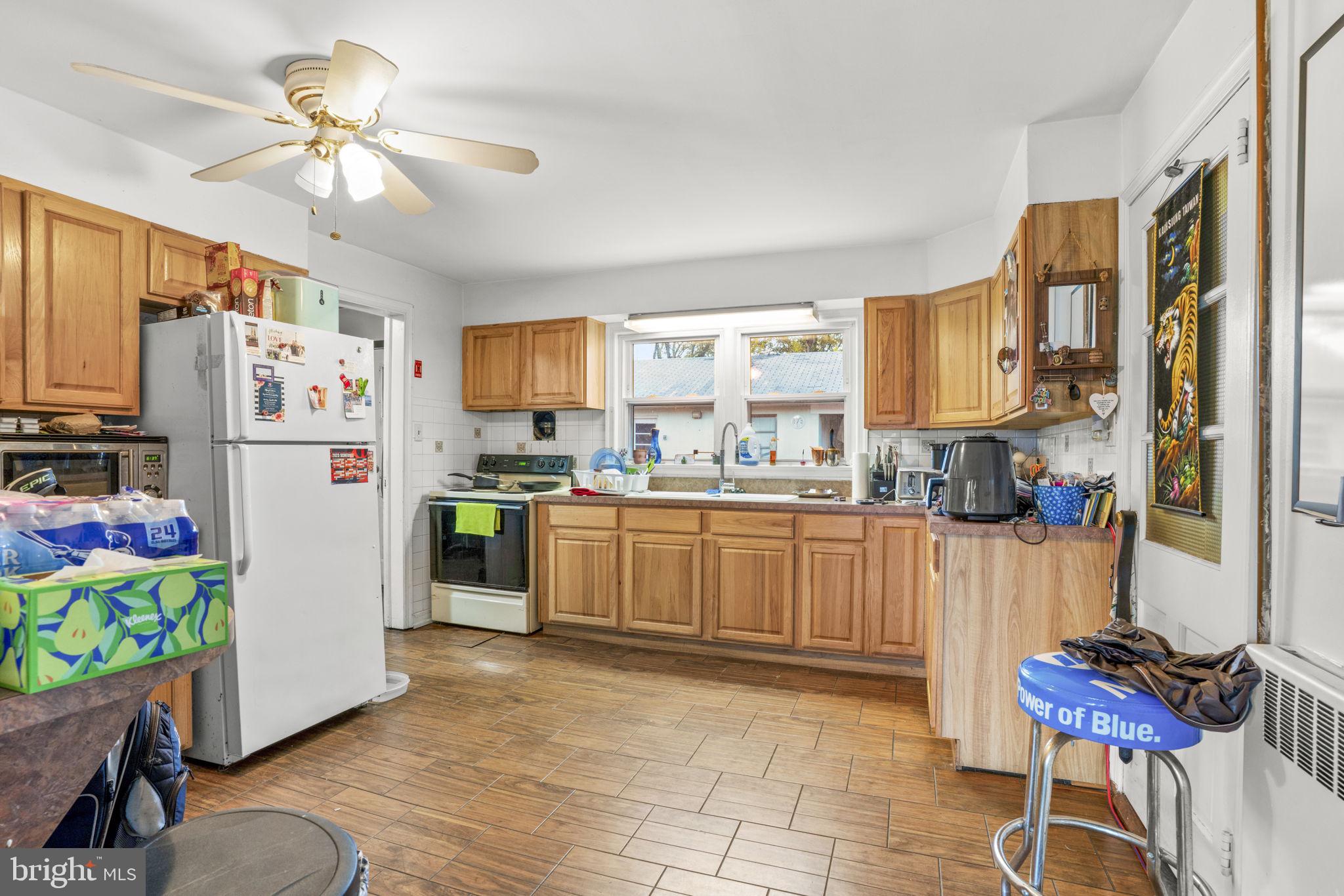 6040 Melbourne Avenue Deale, MD 20751 - Photo 5 of 37 a kitchen with stainless steel appliances a refrigerator a stove a sink dishwasher and a dining table with wooden floor