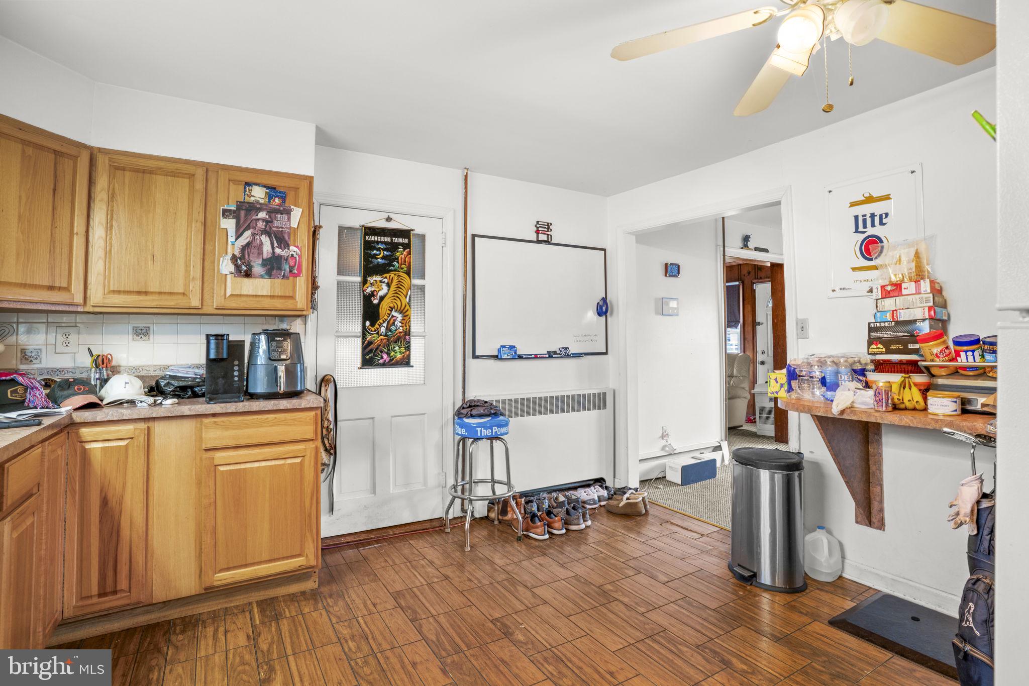 6040 Melbourne Avenue Deale, MD 20751 - Photo 7 of 37 a kitchen with stainless steel appliances a stove top oven a refrigerator a dining table and chairs with wooden floor