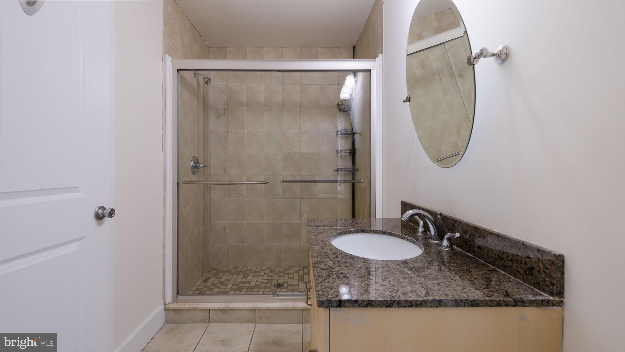 436 Sloan Street Philadelphia, PA 19104 - Photo 17 of 21 a bathroom with a granite countertop shower sink and mirror