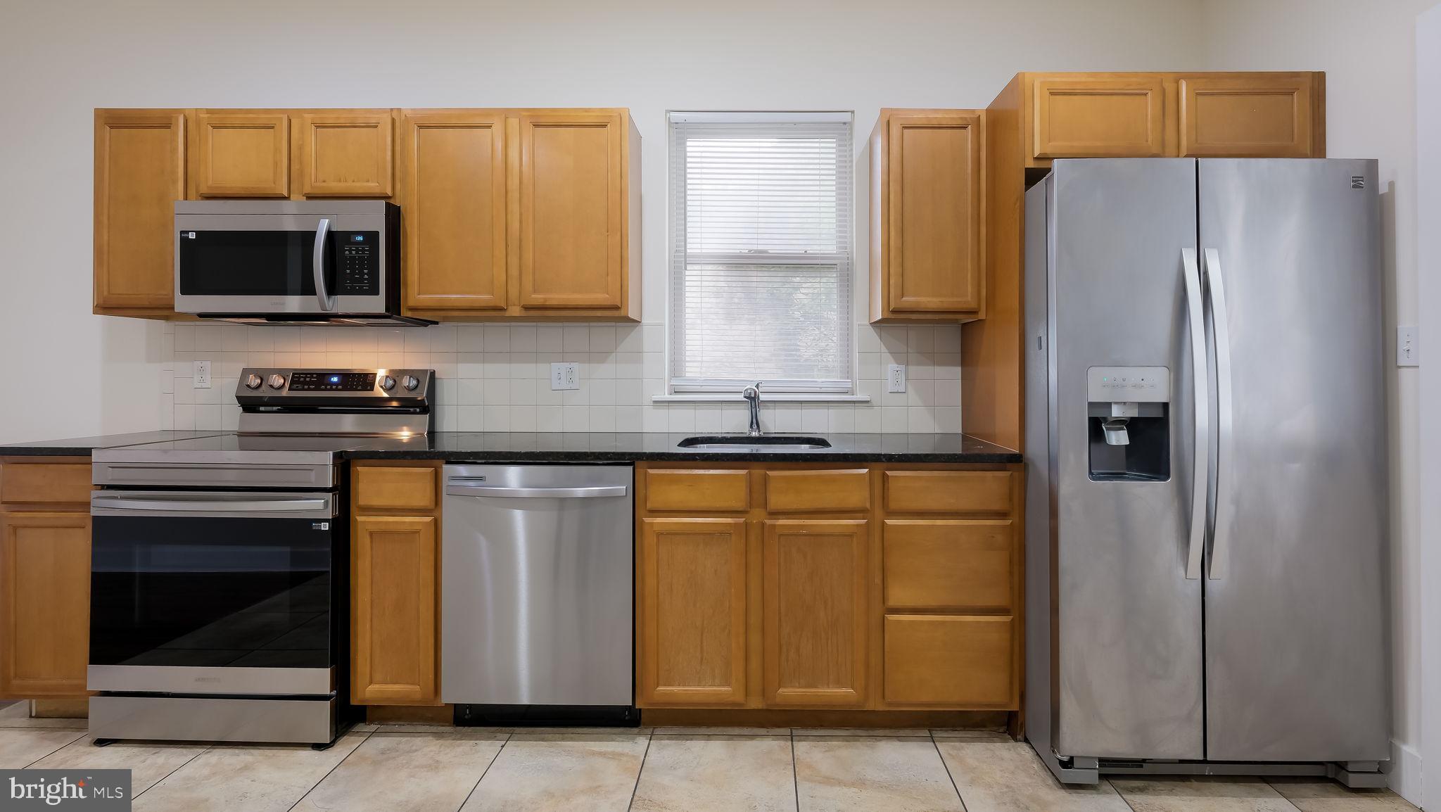 436 Sloan Street Philadelphia, PA 19104 - Photo 7 of 21 a kitchen with stainless steel appliances granite countertop a refrigerator stove and microwave