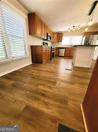 a view of a kitchen with wooden floor and staircase